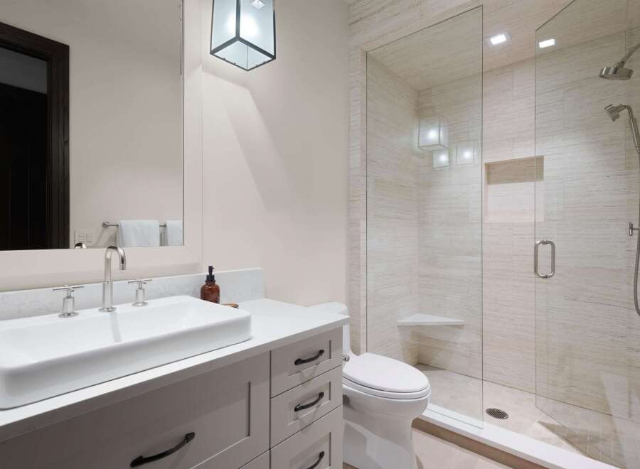 Experience modern luxury in this stunning bathroom featuring a sleek vanity with a vessel sink and a spacious glass-enclosed shower.