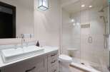Experience modern luxury in this stunning bathroom featuring a sleek vanity with a vessel sink and a spacious glass-enclosed shower.