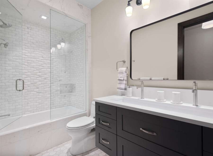 This modern bathroom features a sleek design with a freestanding bathtub and a glass-enclosed shower.