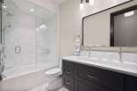 This modern bathroom features a sleek design with a freestanding bathtub and a glass-enclosed shower.