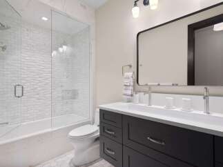 This modern bathroom features a sleek design with a freestanding bathtub and a glass-enclosed shower.