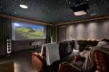 Experience cinematic luxury in this state-of-the-art home theater, featuring plush leather recliners with built-in cup holders and cozy throws.