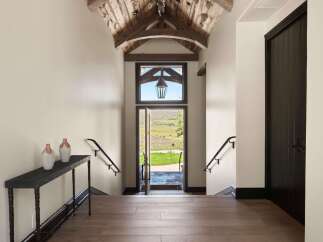 Step into this stunning entryway featuring a vaulted wood-beamed ceiling and a grand lantern.