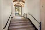 Ascend to luxury in this stunning mountain home, featuring a grand staircase with rich wood treads and a sleek black handrail.