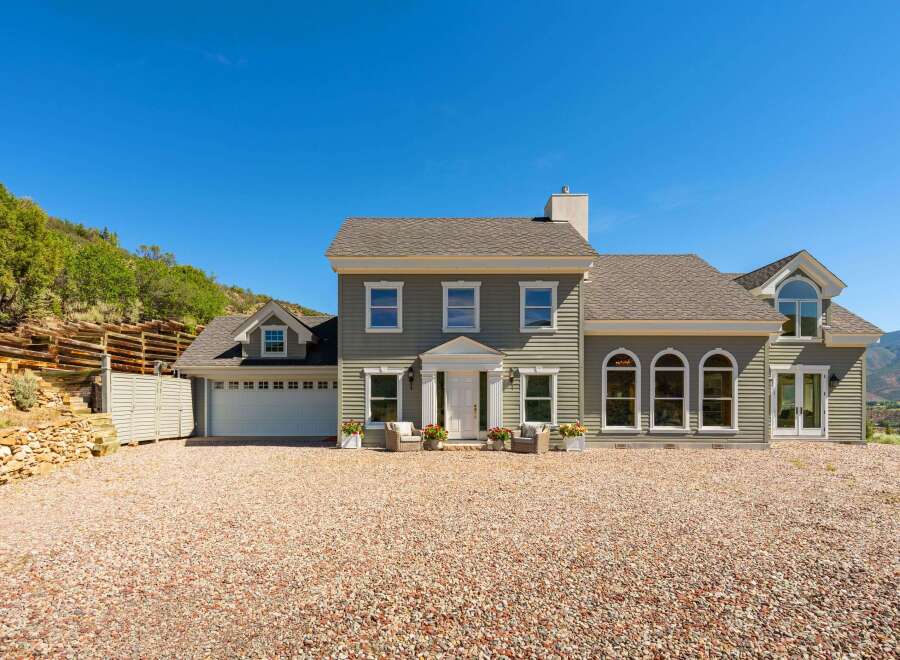 Discover this stunning home featuring a welcoming facade with a prominent entrance and a spacious two-car garage.