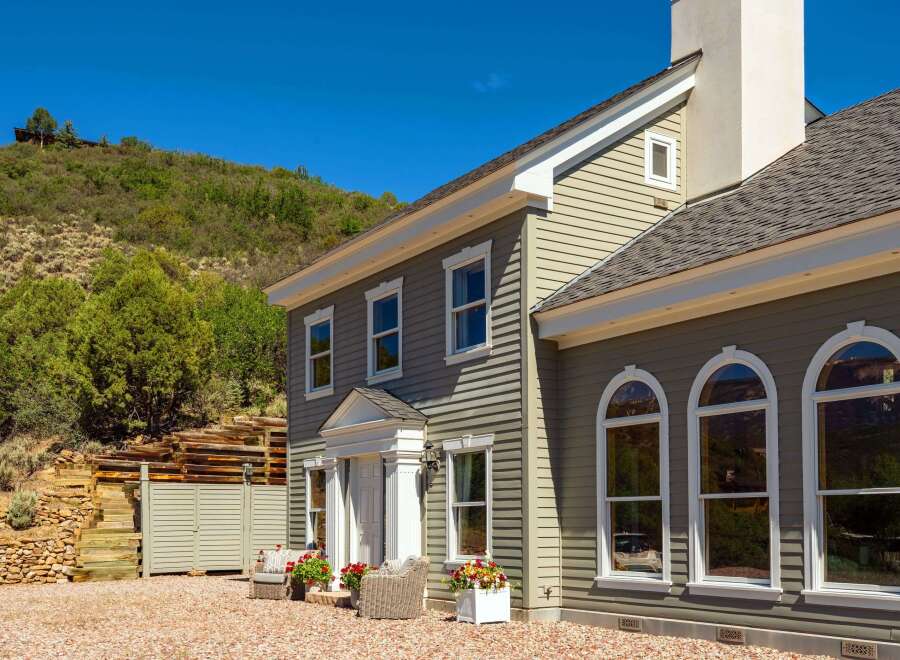 Experience luxury mountain living in this stunning home, featuring elegant siding and a prominent stone chimney.
