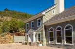 Experience luxury mountain living in this stunning home, featuring elegant siding and a prominent stone chimney.