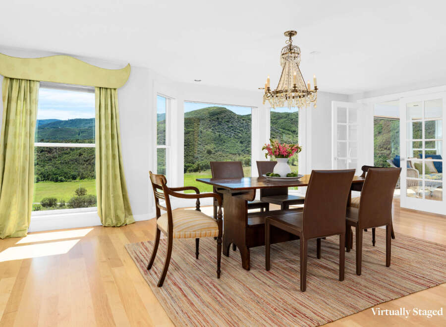 Experience breathtaking mountain views from this elegant dining room, featuring a stunning crystal chandelier and large windows that flood the space with natural light.
