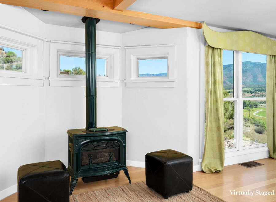 Cozy up by the green cast-iron wood stove in this charming room, perfect for chilly evenings.