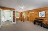 Step into a charming mountain retreat featuring warm wood paneling throughout and a welcoming entryway.
