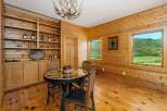 Experience rustic charm in this dining area featuring warm, knotty pine wood paneling throughout.