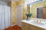 This charming bathroom features a vibrant yellow toile wallpaper that adds a touch of classic elegance.