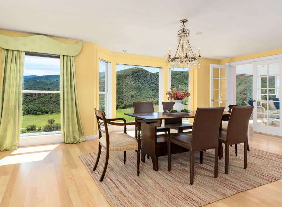Experience breathtaking mountain views from this elegant dining room, featuring a stunning crystal chandelier and large windows that flood the space with natural light.