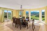 Enjoy breathtaking mountain views from this elegant dining room, featuring a large wooden table with comfortable seating and a stunning crystal chandelier.