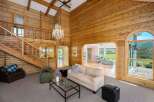 Experience rustic charm and breathtaking views in this stunning log cabin-style living room.