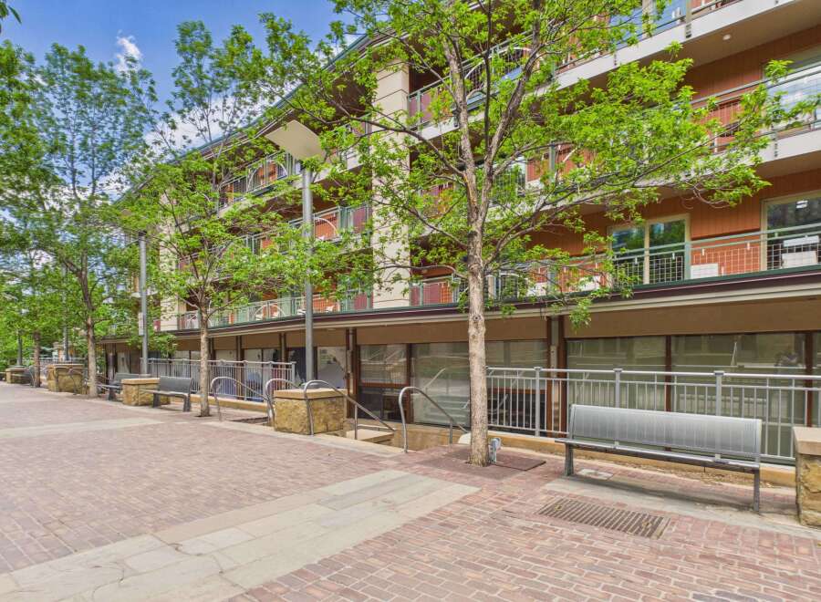 Discover modern living in this vibrant urban setting, featuring a multi-story building with balconies and large windows.