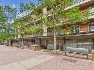 Discover modern living in this vibrant urban setting, featuring a multi-story building with balconies and large windows.