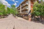 Discover this charming property featuring a multi-story building with balconies overlooking a picturesque brick-paved street lined with trees.