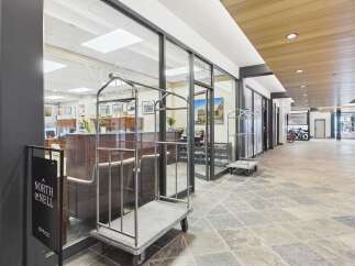 Experience the welcoming ambiance of this property's lobby, featuring a modern design with elegant wood accents and a spacious, well-lit interior.