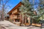 Experience luxury mountain living in this stunning property featuring a warm, wood-accented exterior and multiple balconies perfect for enjoying the crisp alpine air.