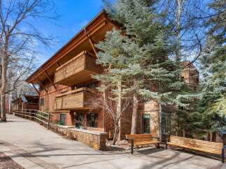 Experience luxury mountain living in this stunning property featuring a warm, wood-accented exterior and multiple balconies perfect for enjoying the crisp alpine air.