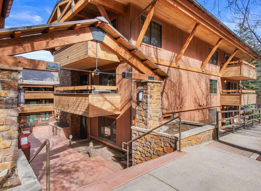 Experience mountain living in this stunning timber-framed residence, featuring natural stone accents and expansive wooden balconies perfect for enjoying the crisp alpine air.