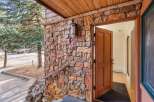 Step into this charming home through a beautiful wooden door, set against a rustic stone exterior.