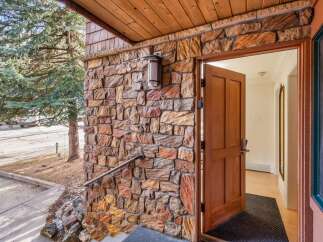 Step into this charming home through a beautiful wooden door, set against a rustic stone exterior.