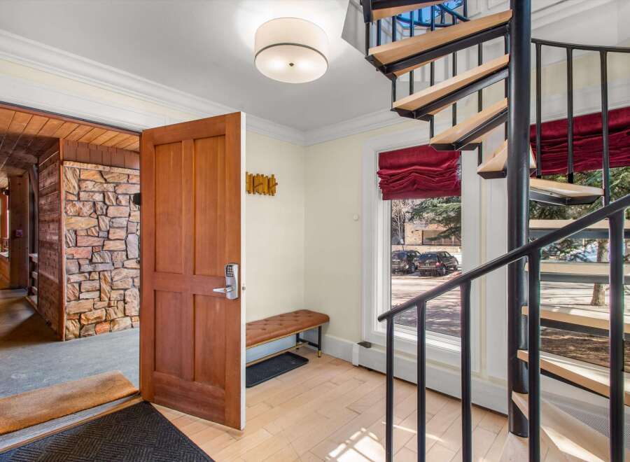 Step into this inviting entryway featuring a rustic stone accent wall and a warm wooden door with a modern digital lock.