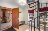 Step into this inviting entryway featuring a rustic stone accent wall and a warm wooden door with a modern digital lock.