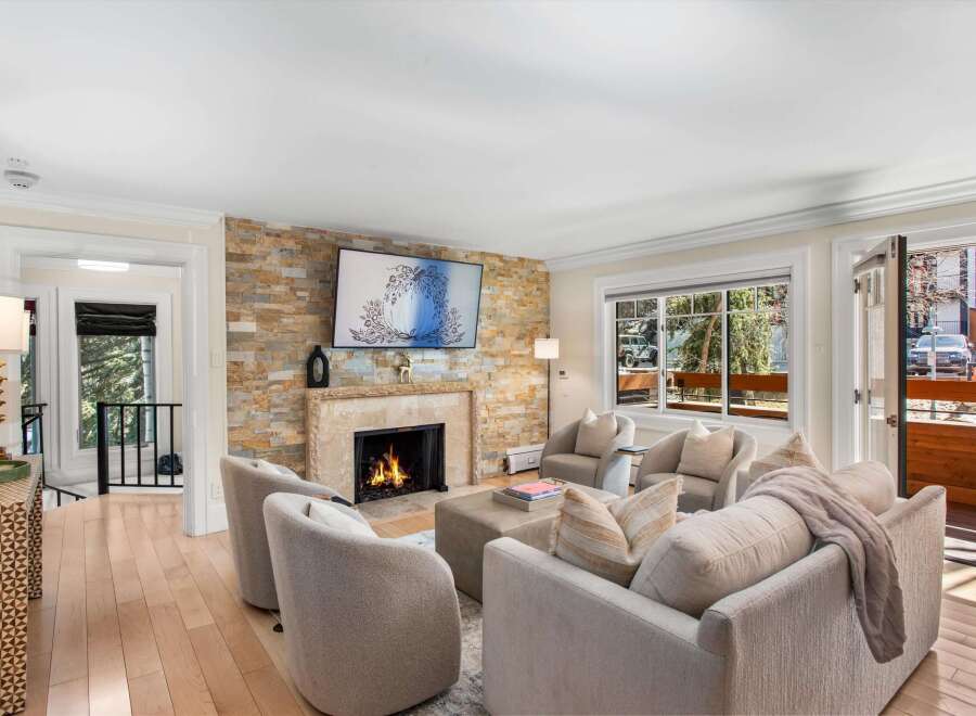 Experience luxury living in this stunning living room, featuring a magnificent stone fireplace as the centerpiece.