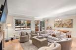Experience cozy living in this inviting living room, featuring a plush sofa adorned with decorative pillows and a soft throw, perfect for relaxing evenings.