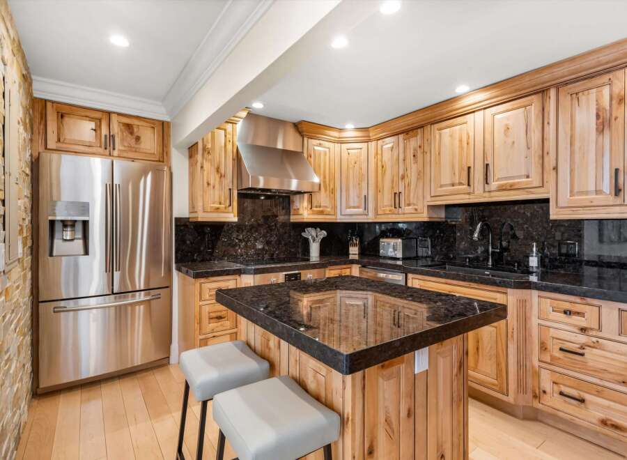 Experience the rustic charm of this beautifully appointed kitchen, featuring custom knotty wood cabinetry and sleek granite countertops.