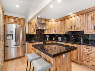 Experience the rustic charm of this beautifully appointed kitchen, featuring custom knotty wood cabinetry and sleek granite countertops.
