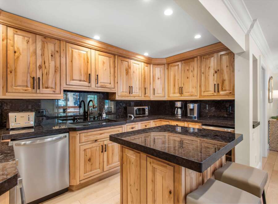 Experience the warmth and character of this stunning kitchen, featuring custom knotty wood cabinetry and sleek granite countertops.