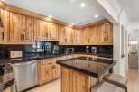 Experience the warmth and character of this stunning kitchen, featuring custom knotty wood cabinetry and sleek granite countertops.