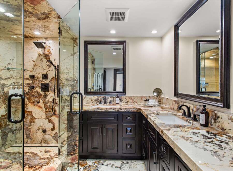 Experience luxury in this stunning bathroom featuring a spacious walk-in shower with exquisite marble walls and multiple shower heads.