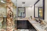 Experience luxury in this stunning bathroom featuring a spacious walk-in shower with exquisite marble walls and multiple shower heads.
