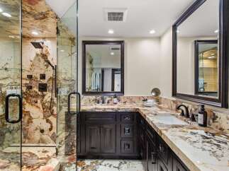 Experience luxury in this stunning bathroom featuring a spacious walk-in shower with exquisite marble walls and multiple shower heads.