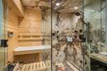 Experience ultimate relaxation in this luxurious spa-like bathroom, featuring a private sauna with wooden interiors and a sleek glass-enclosed shower.