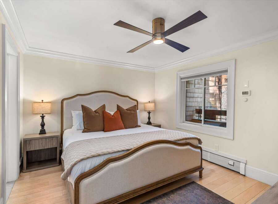 Experience comfort and style in this inviting bedroom, featuring a plush upholstered bed with elegant trim and a coordinating quilted throw.