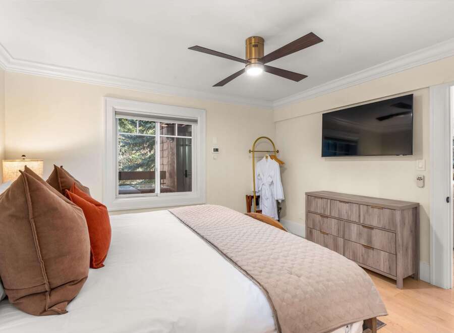 Experience ultimate comfort in this beautifully appointed bedroom, featuring a plush king-sized bed adorned with luxurious pillows and a soft quilted throw.