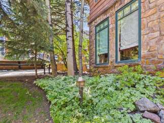 Experience the charm of this mountain retreat, featuring a rustic stone exterior complemented by warm wood siding.