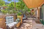 Enjoy the serene outdoor living space on this charming patio, complete with comfortable seating and lush greenery.