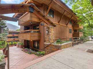 Experience mountain living in this stunning timber-framed residence, featuring natural wood siding and stone accents.