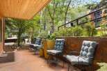 Enjoy the serene outdoor living space with comfortable seating and lush greenery.