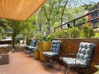 Enjoy the serene outdoor living space with comfortable seating and lush greenery.