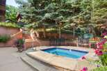 Enjoy a relaxing dip in this private hot tub, surrounded by lush greenery and vibrant flowers.