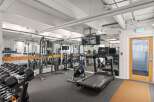 This well-equipped gym features a variety of strength training equipment, including a full dumbbell rack and a multi-functional cable machine.