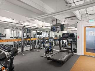 This well-equipped gym features a variety of strength training equipment, including a full dumbbell rack and a multi-functional cable machine.